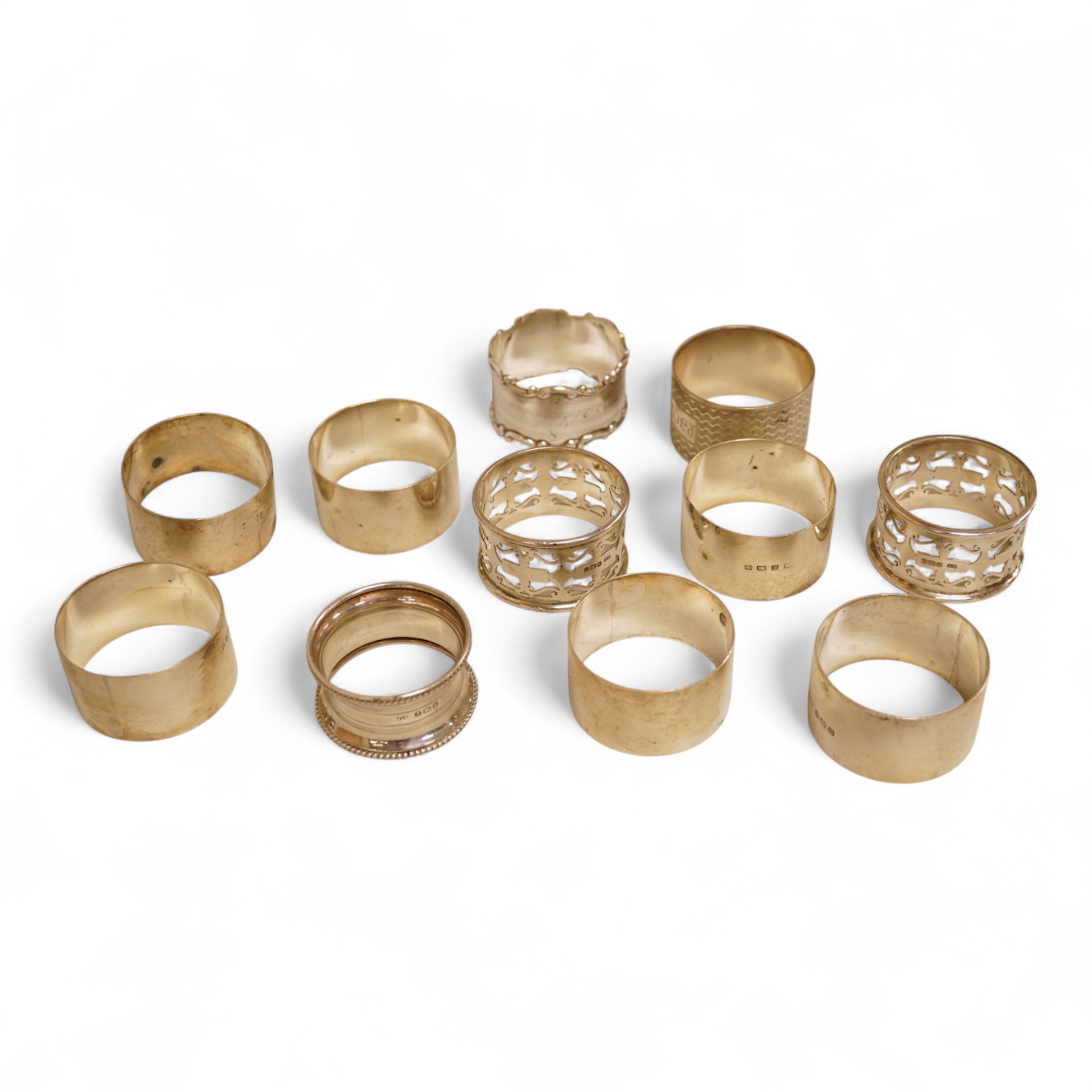 A pair of Edwardian pieced silver napkin rings by Henry Wigfull, Sheffield, 1905, together with nine other assorted silver napkin rings.